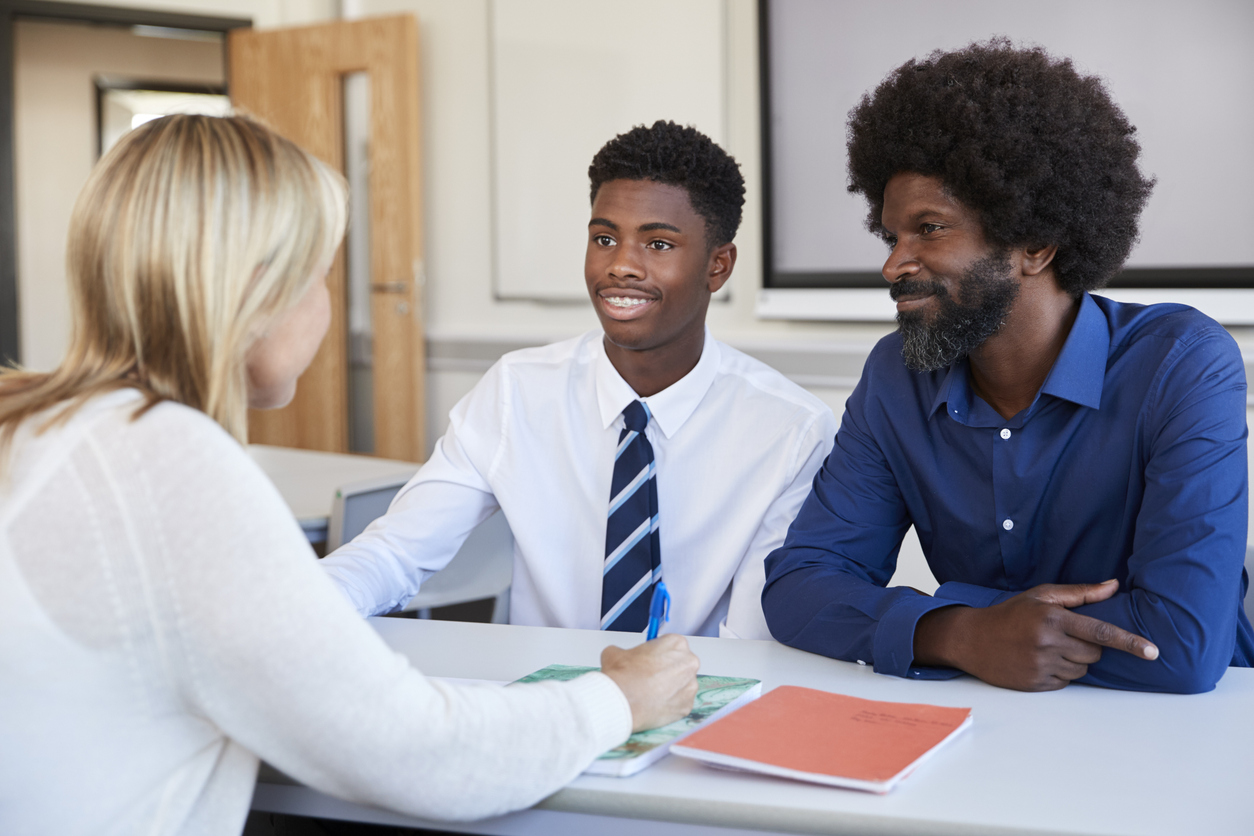 Parent with secondary school student speaking to the teacher